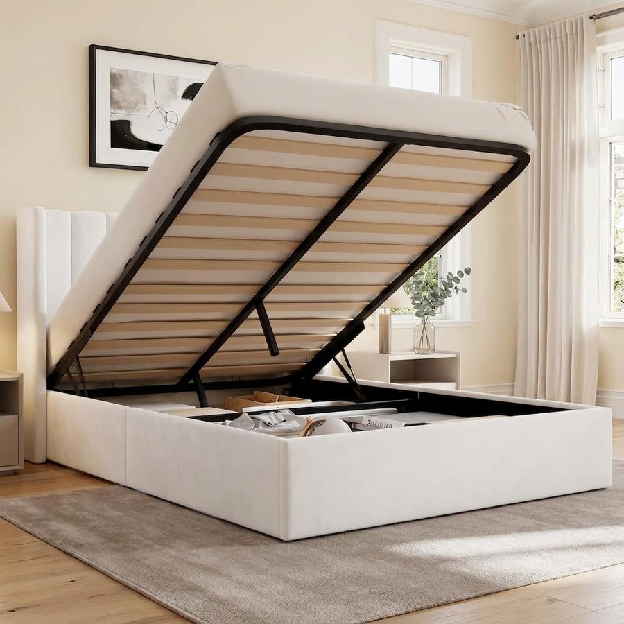White wingback bed frame with hydraulic lift storage in a small studio bedroom